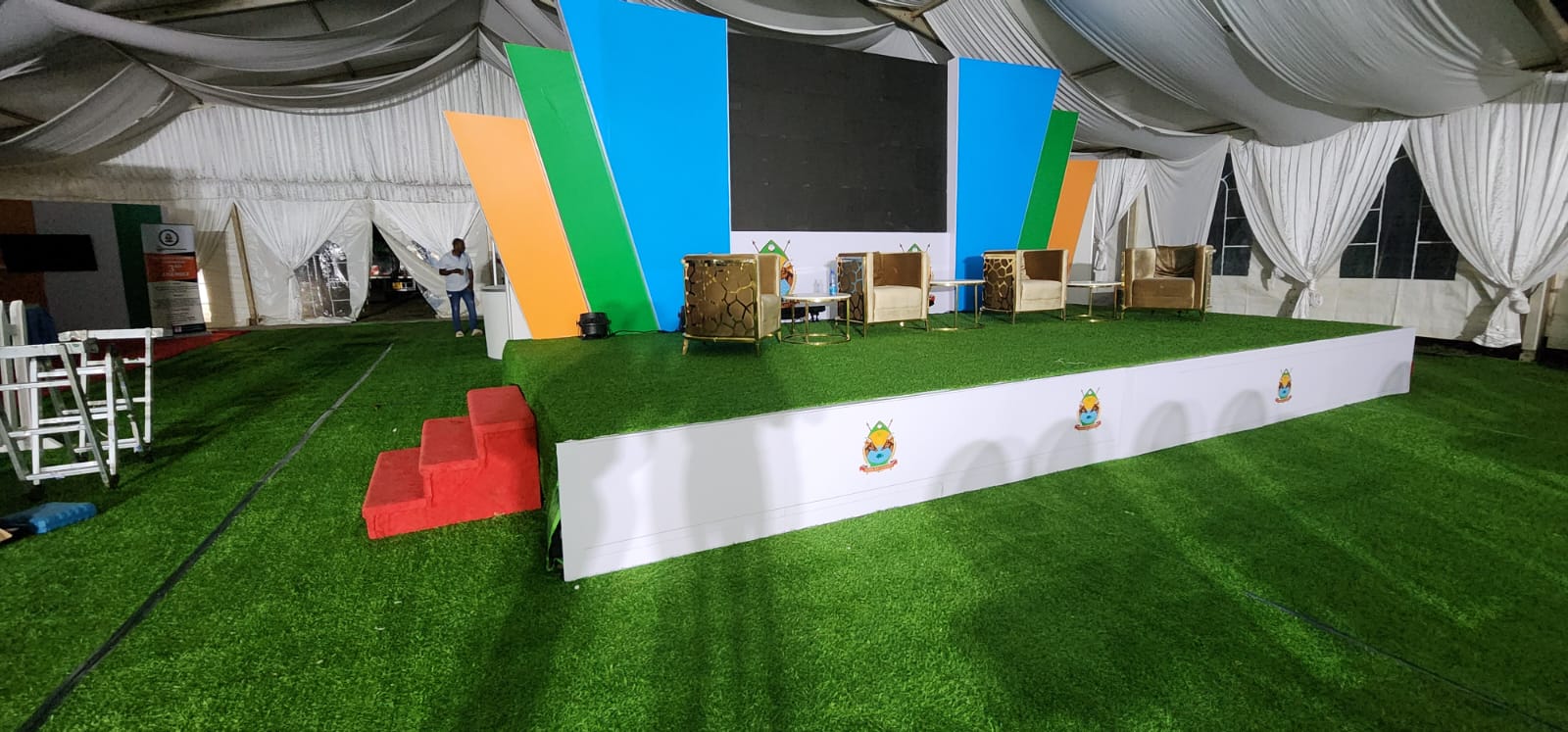 Outdoor marquee stage build with branded backdrop and artificial turf flooring in Kenya