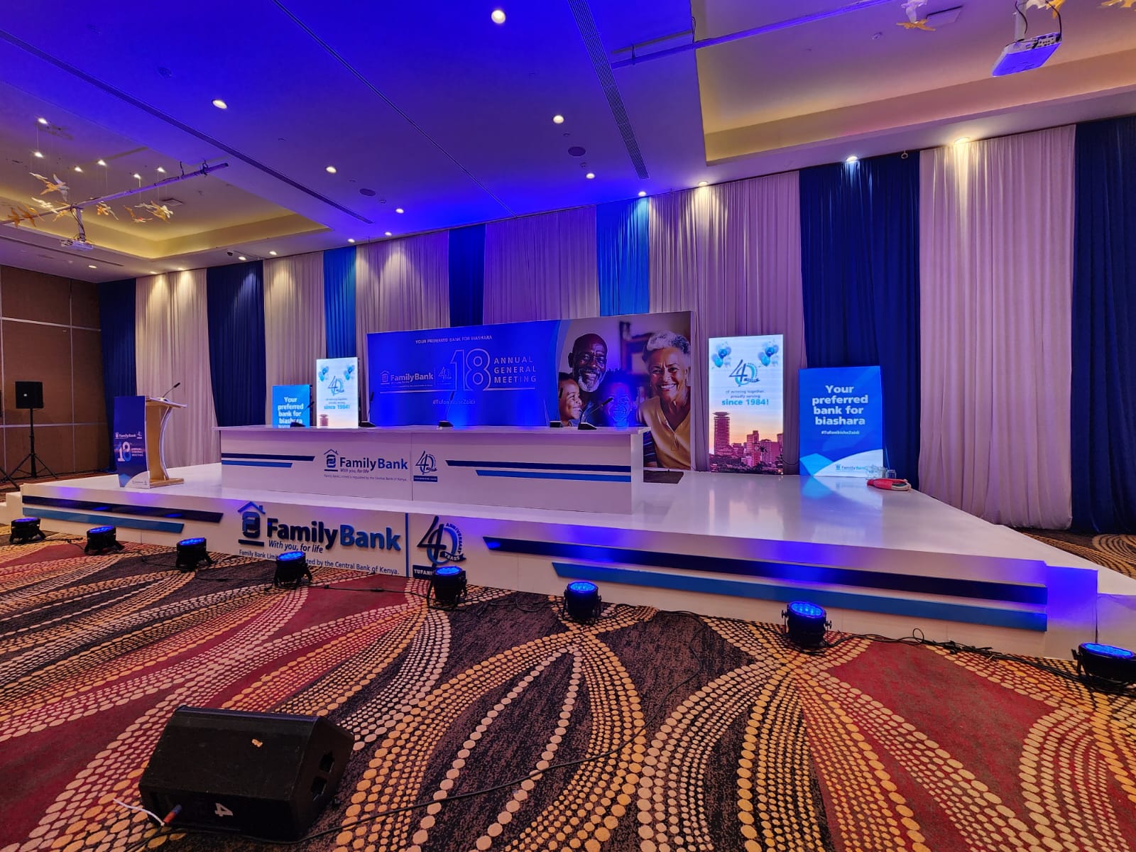 Family Bank 18th Annual General Meeting stage with blue uplighting and branded head table in Nairobi