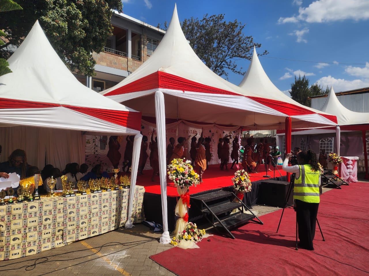 Outdoor marquee prize giving ceremony with trophies, red carpet and cultural dancers in Nairobi